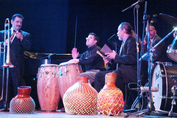 Performing at Flushing Town Hall in Queens, New York for the opening of the exhibition: Latin Jazz: La Combinación Perfecta. April 9, 2003. Left to right, Demetrios, claves, trombone and shekeres, Samuel Torres, conga drums, Angel Rodriguez, bongos, cowbell and shekeres, Solo Rodriguez, bass. Photo credit: Jerry Lacay.