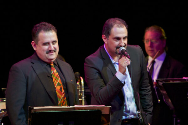 Left Demetrios, right Yannis Economides. Right background, violinist Bob Thomas. Yannis Economides, founder and leader of the Greek Latin Jazz orchestra Aroma Caribe came all the way from Thessaloniki Greece to be featured as a guest soloist with the Latin Jazz Coalition at Flushing Town Hall in Queens, New York. December 10, 2010. Photo credit: Norm Harris.