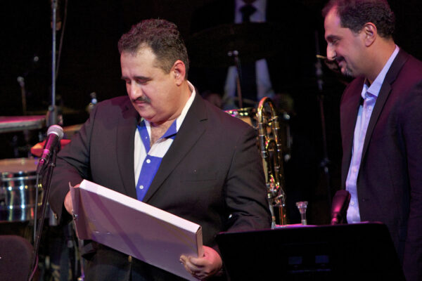 Demetrios gives Yanni a beautiful plaque to take home with him for his performance with the Latin Jazz Coalition at Flushing Town Hall in Queens, New York. December 10, 2010. Photo credit: Norm Harris.