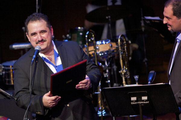 The unveiling of a beautiful plaque from Demetrios to Yannis Economides for Yanni's performance with the Latin Jazz Coalition at Flushing Town Hall in Queens, New York. December 10, 2010. Photo credit: Norm Harris.